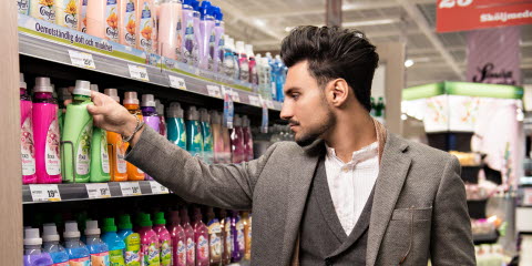 Man looking at softner bottle in a store