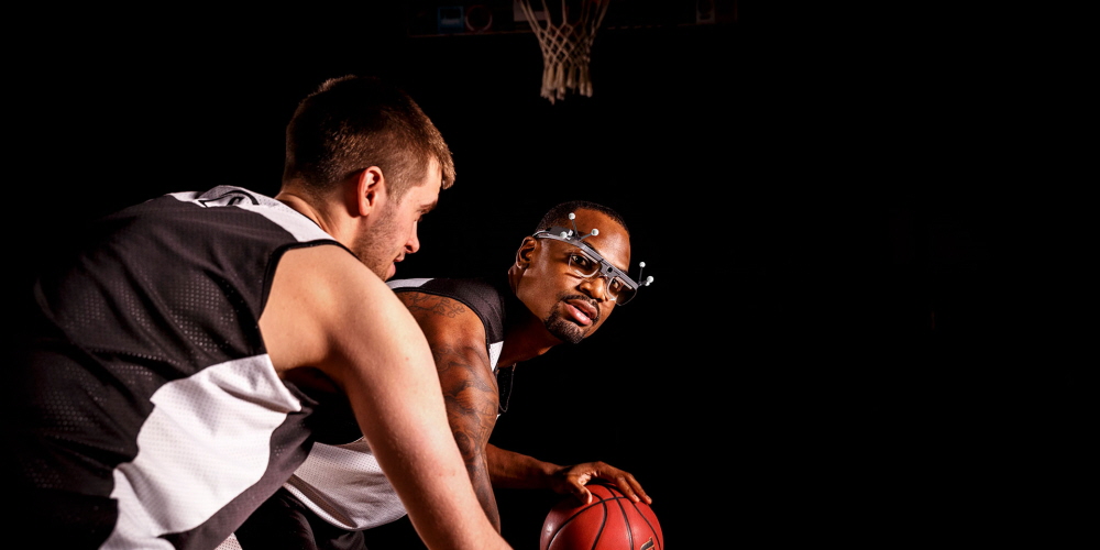A basketball player wearing Tobii Pro Glasses 2 with reflective markers for motion capture from Qualisys