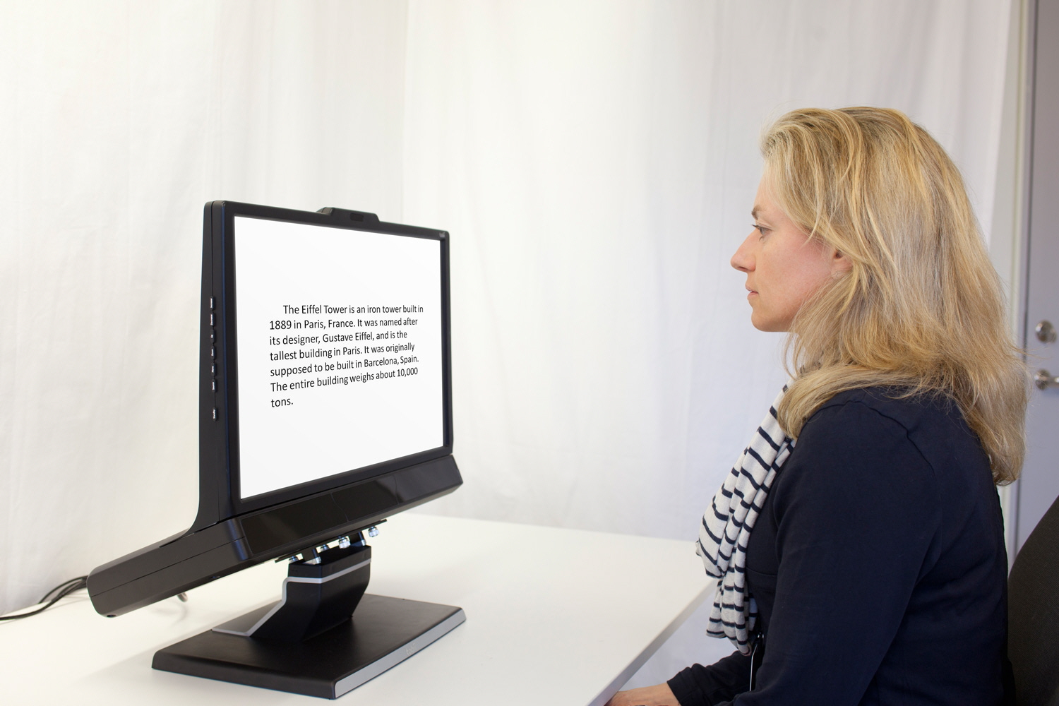 A woman reading a text displayed on the screen of the Tobii Pro TX300
