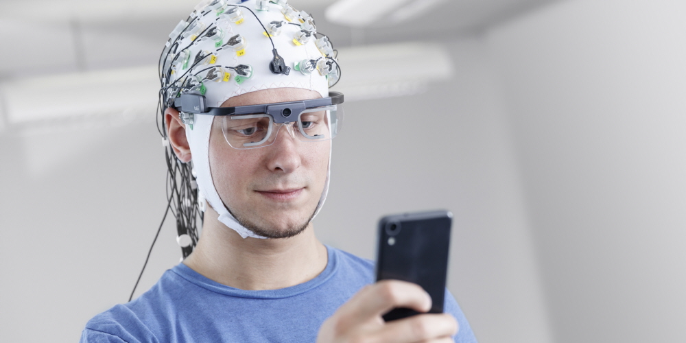 A person wearing Tobii Pro Glasses 2 synchronized with EEG 