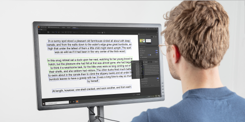 A man reading a text from a desktop screen
