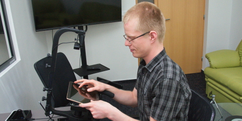 A person sitting in front of the Tobii Pro X2-60 eye tracker mounted on the desk stand.